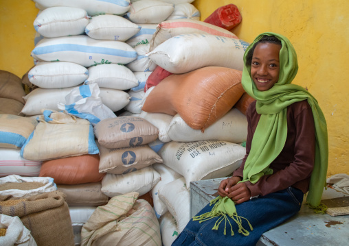 Eritrean girl in a warehouse full of grains bags, Central region, Asmara, Eritrea