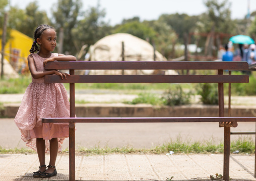 Eritrean girl leaning on a bench in the street, Central region, Asmara, Eritrea