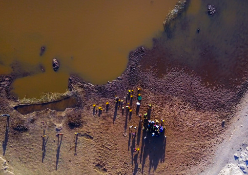 Aerial view of Borana tribe people filling jerricans in a water reservoir used for animals, Oromia, Yabelo, Ethiopia