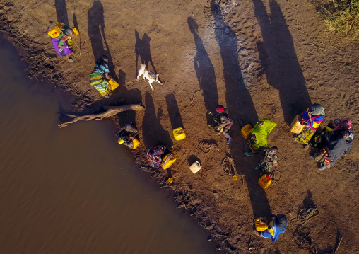 Aerial view of Borana tribe people filling jerricans in a water reservoir used for animals, Oromia, Yabelo, Ethiopia
