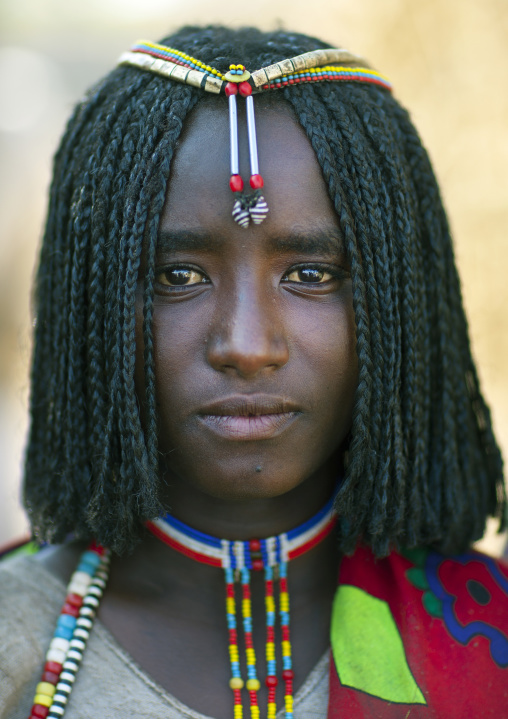 Portrait Of A Shy Karrayyu Tribe Girl With Stranded Hair And Colourful Jewels, Gadaaa Ceremony, Metehara, Ethiopia
