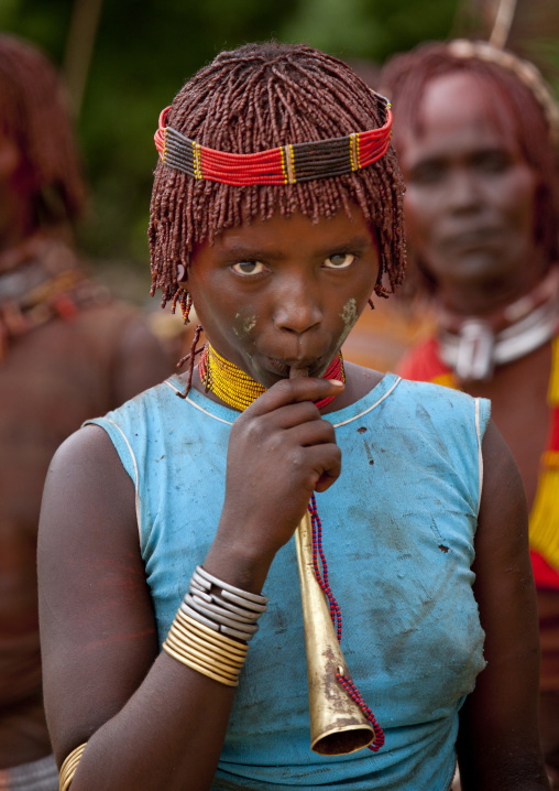 Hamer Tribe Woman With Ochred Hair Blowing A Horn During Bull Leaping Ceremony, Omo Valley, Ethiopia