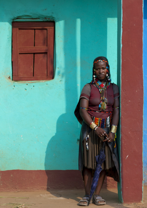 Traditional clothing ara woman posing outside of blue house in jinka omo valley Ethiopia