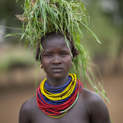 Dassanech Young Woman Carrying Load Of Green Grass On Head And Beaded Necklaces Omo Valley Ethiopia