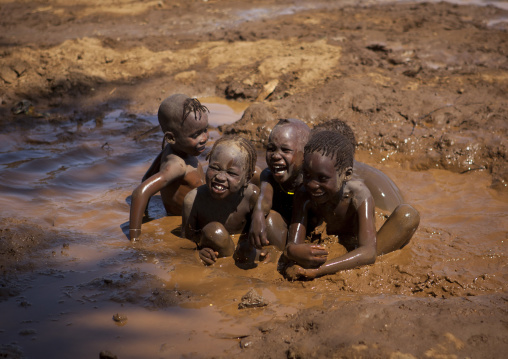 Nyangatom Kids Playing In Muddy Water, Kangate, Omo Valley, Ethiopia