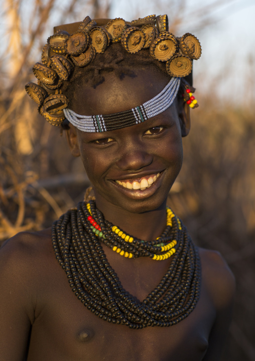 Portrait Of A Young Dassanech Girl Wearing Bottle Caps Headgear And Beaded Necklaces, Omorate, Omo Valley, Ethiopia