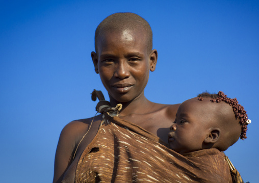 Portrait Of A Bodi Tribe Mother Carrying Her Baby, Hana Mursi, Omo Valley, Ethiopia