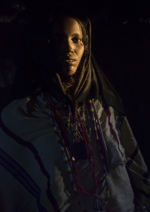 Karrayyu Tribe Woman Inside Her House Lighten By A Ray Of Light, Metahara, Ethiopia