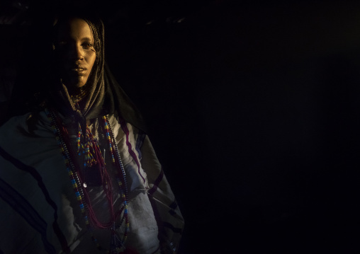 Karrayyu Tribe Woman Inside Her House Lighten By A Ray Of Light, Metahara, Ethiopia
