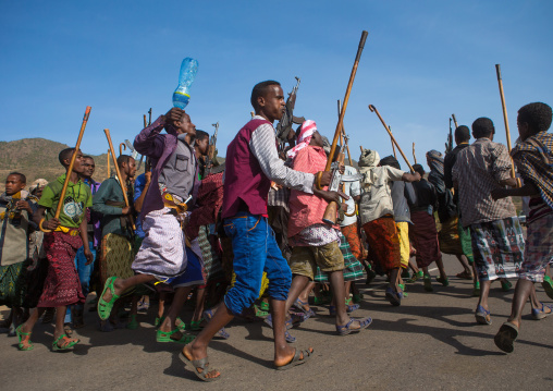 Oromo men with canes and kalashnikovs dancing during a wedding celebration, Oromo, Sambate, Ethiopia