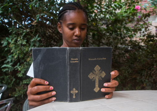 A karrayyu tribe girl called aliya reading bible in oromo language, Addis abeba region, Addis ababa, Ethiopia