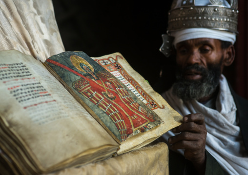 Ethiopian orthodox priest with an old bible in nakuto lab rock church, Amhara region, Lalibela, Ethiopia