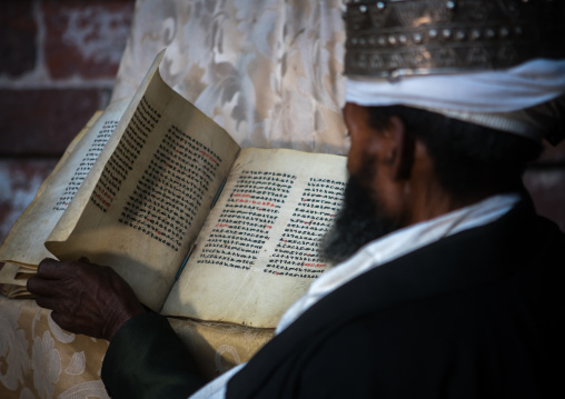 Ethiopian orthodox priest with an old bible in nakuto lab rock church, Amhara region, Lalibela, Ethiopia