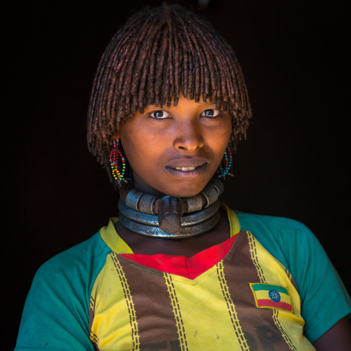 Portrait of a hamer tribe woman with ethiopia football shirt, Omo valley, Turmi, Ethiopia