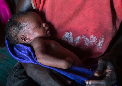 Toposa mother with her new born baby in her hut, Omo valley, Kangate, Ethiopia