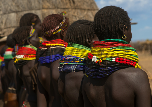 Nyangatom tribe women with huge necklaces in a line, Omo valley, Kangate, Ethiopia