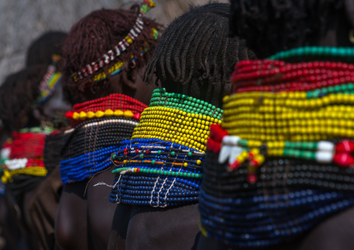 Nyangatom tribe women with huge necklaces in a line, Omo valley, Kangate, Ethiopia
