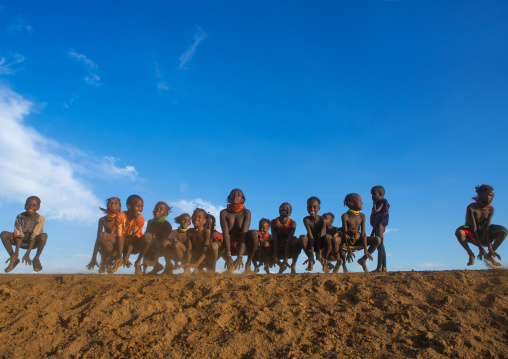 Dassanech tribe children dancing and jumping, Omo valley, Omorate, Ethiopia