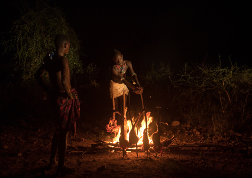 Hamer tribe teenage boys cooking a bbq goat, Omo valley, Turmi, Ethiopia