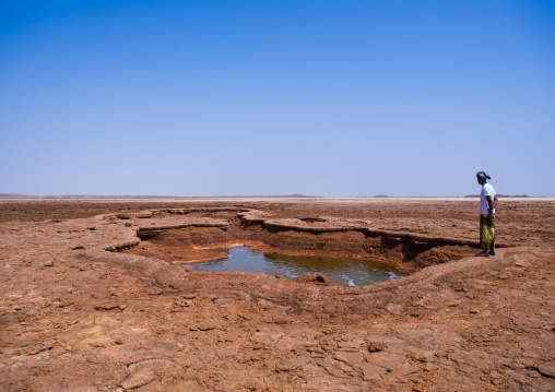Afar man in front of an acid lake in the danakil depression, Afar region, Dallol, Ethiopia