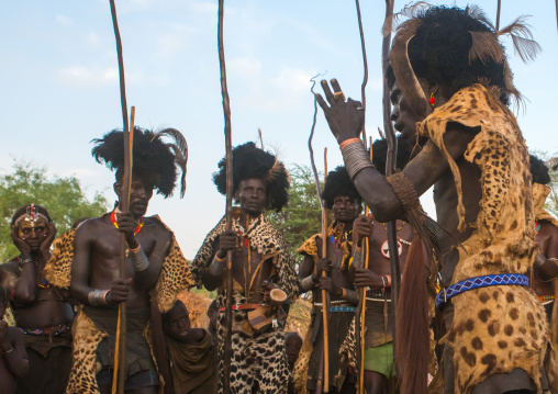 Dassanech men with leopard skins and ostrich feathers headwears during dimi ceremony to celebrate circumcision of teenagers, Omo valley, Omorate, Ethiopia