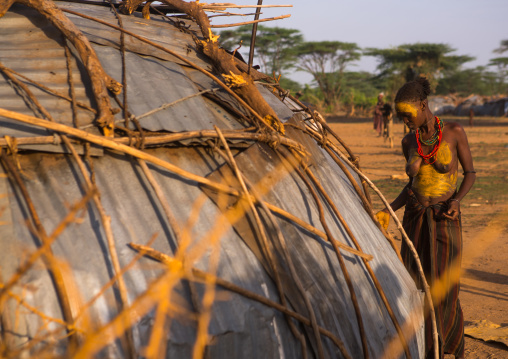 Dassanech tribe woman in front of her house built for the dimi ceremony, Omo valley, Omorate, Ethiopia