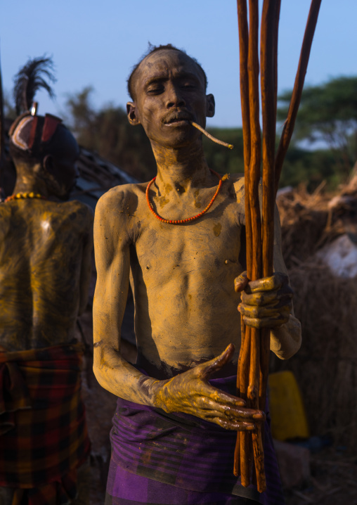 Dassanech man preparing the long sticks for dimi ceremony to celebrate circumcision of teenagers, Omo valley, Omorate, Ethiopia