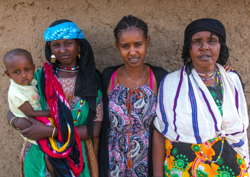 A karrayyu tribe girl called aliya who was the first girl educated in her tribe pausing with her family, Oromia, Metehara, Ethiopia