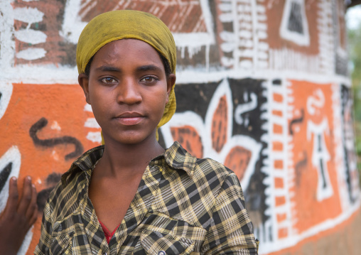 Ethiopia, Kembata, Alaba Kuito, ethiopian woman standing in front of her traditional painted house