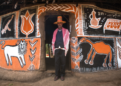 Ethiopia, Kembata, Alaba Kuito, ethiopian muslim man with a hat standing in front of his traditional painted house