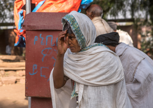 Pilgrim woman praying during kidane mehret orthodox celebration, Amhara region, Lalibela, Ethiopia