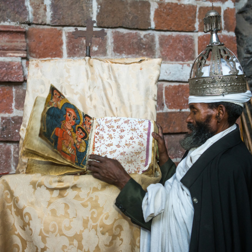 Ethiopian orthodox priest with an old bible in nakuto lab rock church, Amhara region, Lalibela, Ethiopia