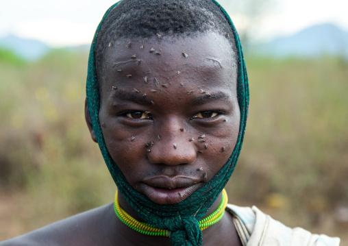 Portrait of a bodi tribe man with flies on his face, Omo valley, Hana mursi, Ethiopia
