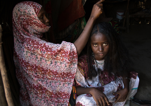 Afar woman having a traditional hairstyle inside her hut, Afar region, Afambo, Ethiopia