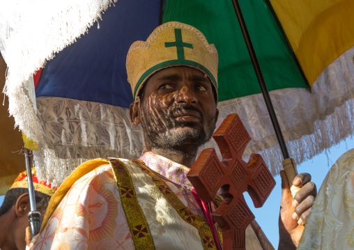 Ethiopian orthodox priest with a cross celebrating the colorful Timkat epiphany festival, Amhara region, Lalibela, Ethiopia