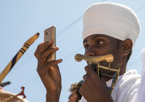 Priest of the ethiopian orthodox church taking pictures with his mobile phone, Amhara region, Lalibela, Ethiopia