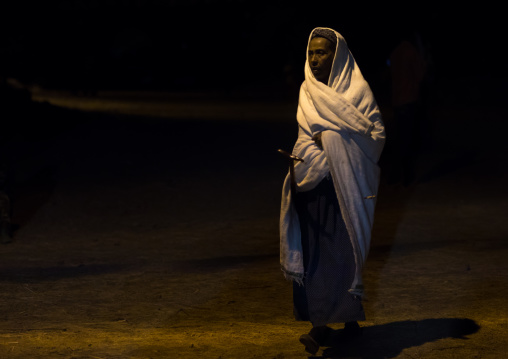 Pilgrim woman walking in the night during Timkat festival, Amhara region, Lalibela, Ethiopia