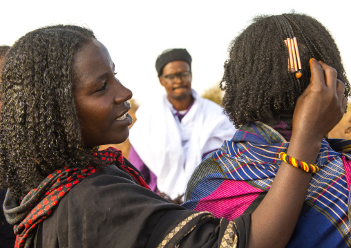 Borana tribe woman adjusting the hair decoration of a friend that indicates how many children she had, Oromia, Yabelo, Ethiopia