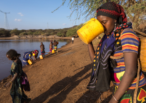Borana tribe woman drinking water taken from a reservoir used for animals, Oromia, Yabelo, Ethiopia