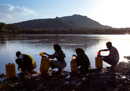 Borana tribe people filling jerricans in a water reservoir used for animals, Oromia, Yabelo, Ethiopia