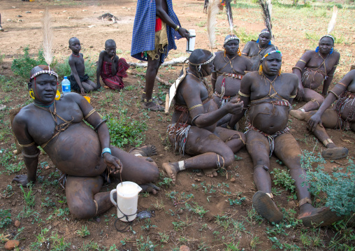 Bodi tribe fat men resting during Kael ceremony, Omo valley, Hana Mursi, Ethiopia