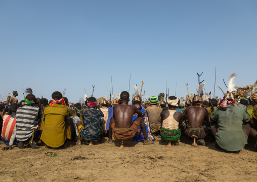 Tribe warriors during the proud ox ceremony in the Dassanech tribe waiting to share the cow meat, Turkana County, Omorate, Ethiopia