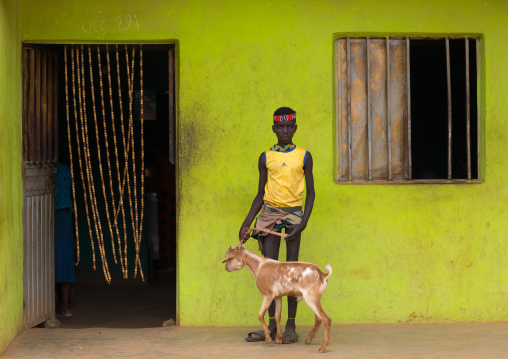 Bana tribe boy with his goat in front of a bar, Omo valley, Key Afer, Ethiopia