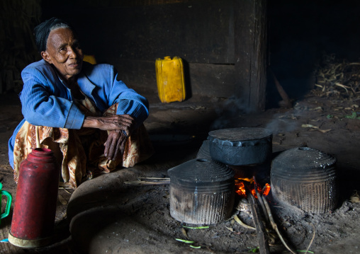 Gurage woman inside her traditional house in front of the fireplace, Gurage Zone, Butajira, Ethiopia