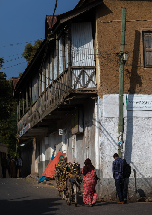 Harari people passing in front of an old house with a wooden balcony, Harari Region, Harar, Ethiopia