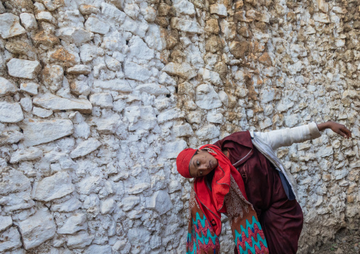Sufi woman with a red veil into trance during a muslim ceremony, Harari Region, Harar, Ethiopia