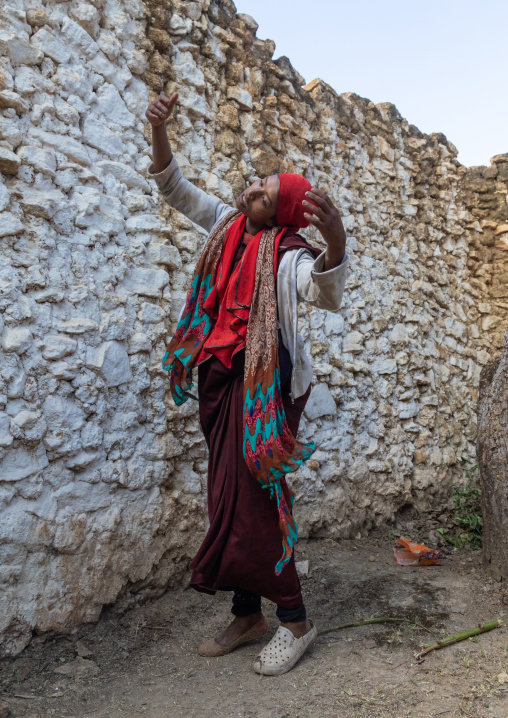 Sufi woman with a red veil into trance during a muslim ceremony, Harari Region, Harar, Ethiopia