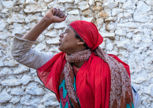 Sufi woman with a red veil into trance during a muslim ceremony, Harari Region, Harar, Ethiopia