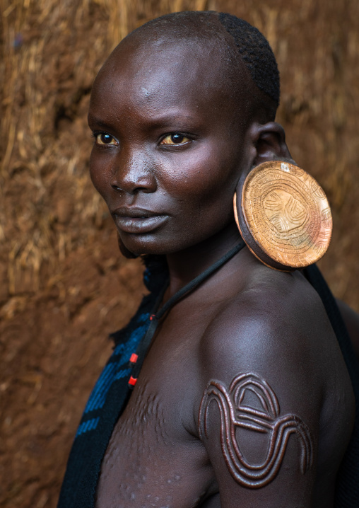 Portrait of a suri tribe woman with enlarged earlobes and huge earrings, Omo valley, Kibish, Ethiopia