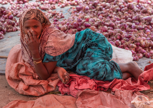 Ethiopian woman lying on the floor and selling oinions, Oromia, Hirna, Ethiopia